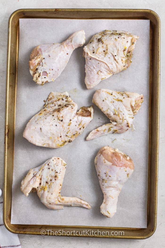 seasoned chicken on a sheet pan to make Lemon Rosemary Chicken