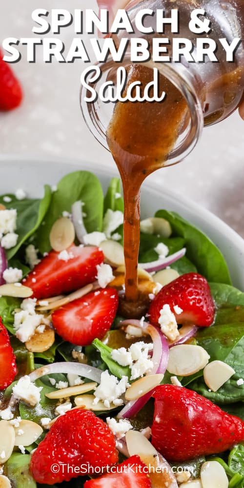 Dressing being poured onto Spinach and Strawberry Salad in a white bowl, with a title