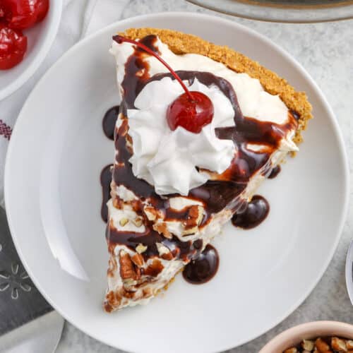 Banana Split Pie slice with chocolate syrup , whipped topping and cherry on top