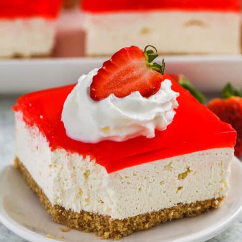 close up of No Bake Strawberry Cheesecake Bars with a bite taken out of one