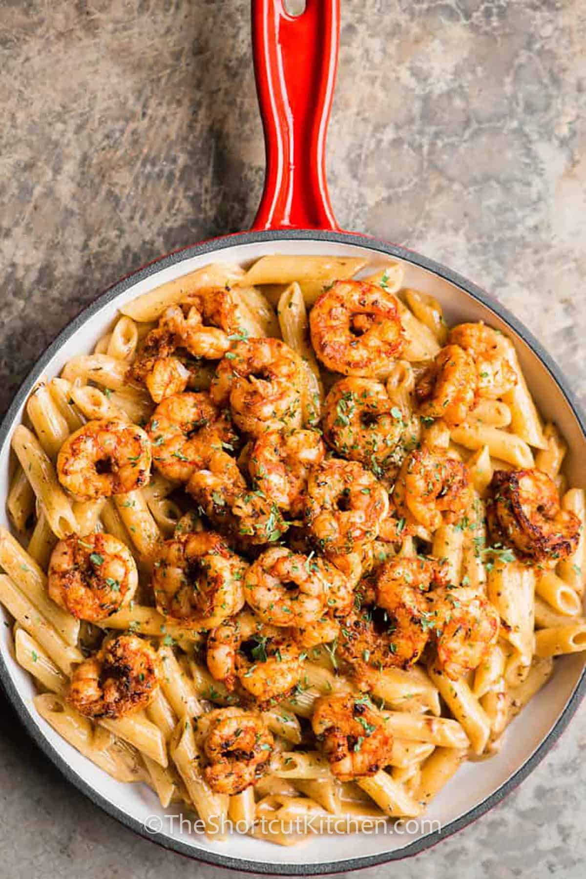adding shrimp to noodles to make Cajun Shrimp Pasta Recipe