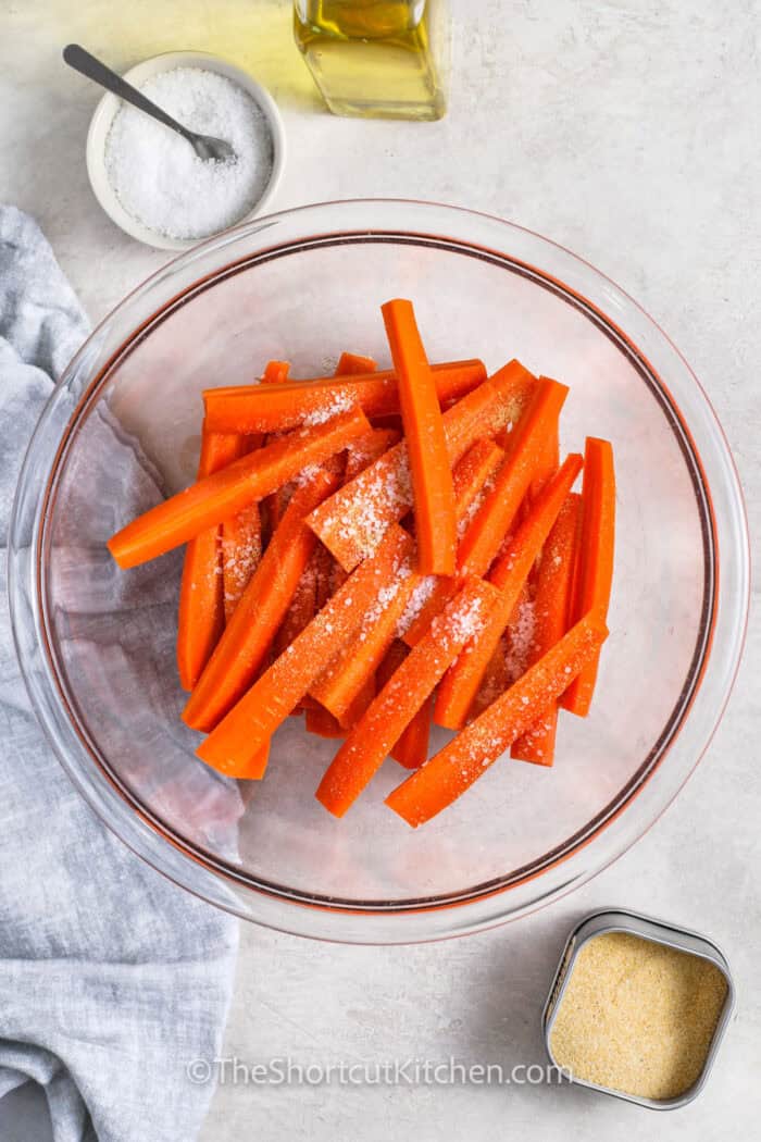 adding seasonings to carrots to make Carrot Fries