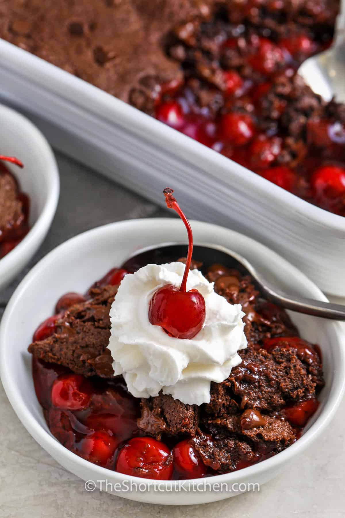 Chocolate Cherry Dump Cake with whipped cream and cherry on top