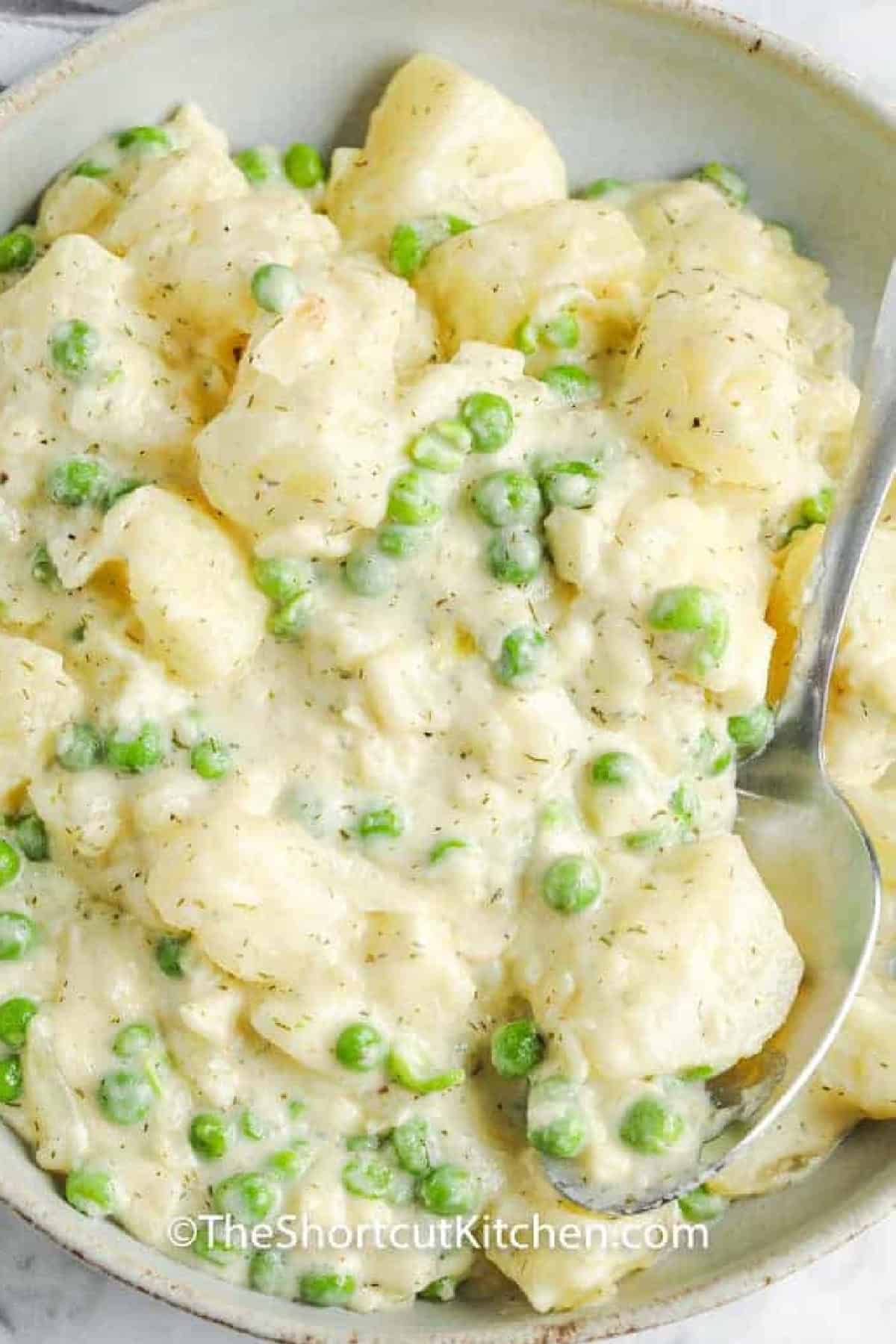 Creamy Potatoes and Peas in a bowl with a spoon