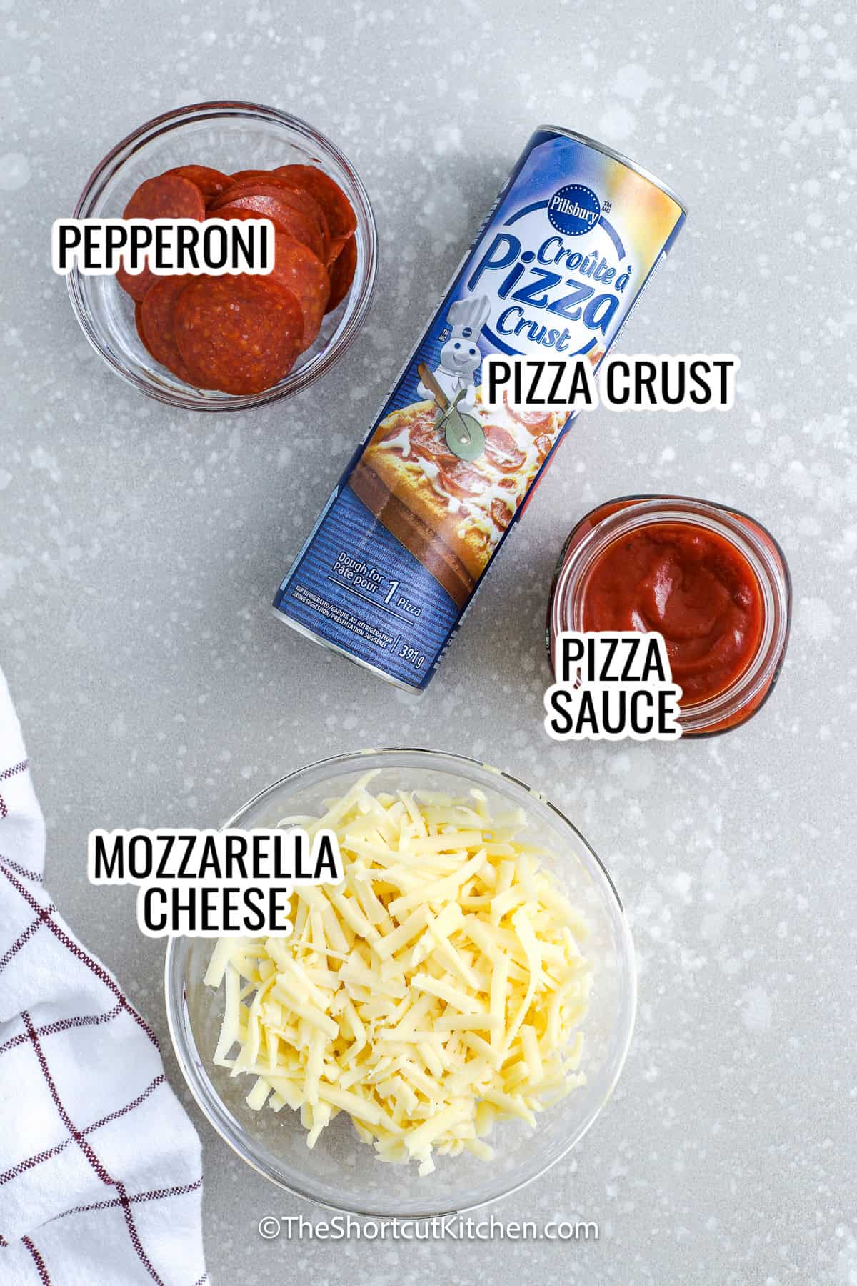 ingredients assembled to make grilled pizza, including mozzarella cheese, pepperoni, pizza crust, and pizza sauce