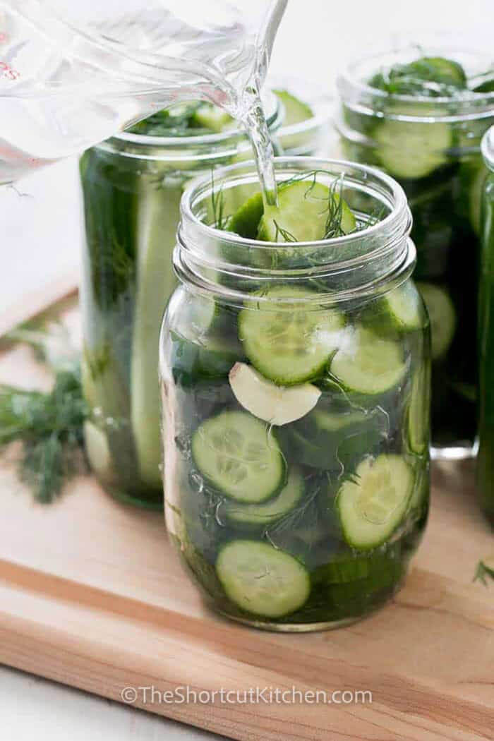 adding brine to jar to make Refrigerator Dill Pickle Recipe