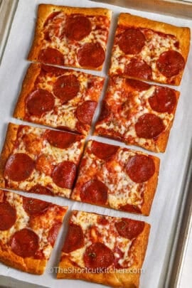 slices of Crescent Roll Pizza on a sheet pan