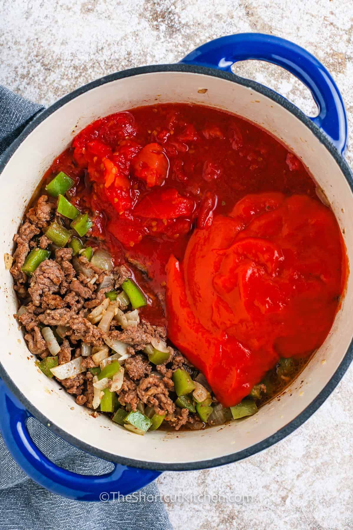 Hamburger macaroni soup is quick comfort in a bowl. Brown ground beef, then stir in chili powder and oregano for a warm flavor. The tomato base comes together with condensed tomato soup and diced tomatoes, plus beef broth for richness. Add elbow pasta and simmer until tender. This hamburger soup with macaroni is great for cold nights and reheats well. #theshortcutkitchen ingredients for hamburger macaroni soup in a pot