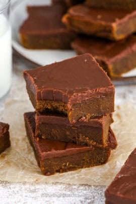 3 pumpkin brownies stacked with a bite taken out of the top piece