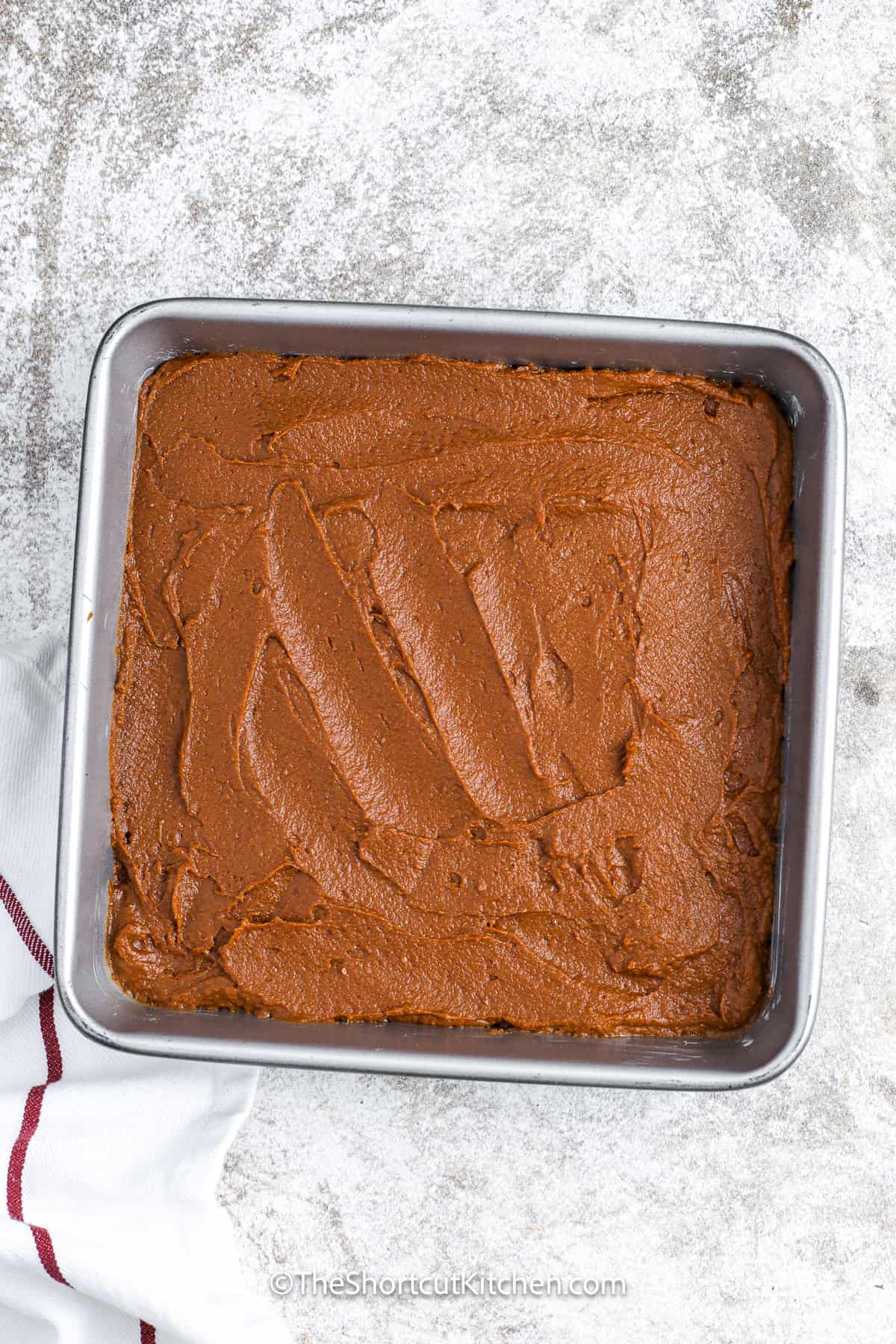 Pumpkin brownies in a baking dish iced