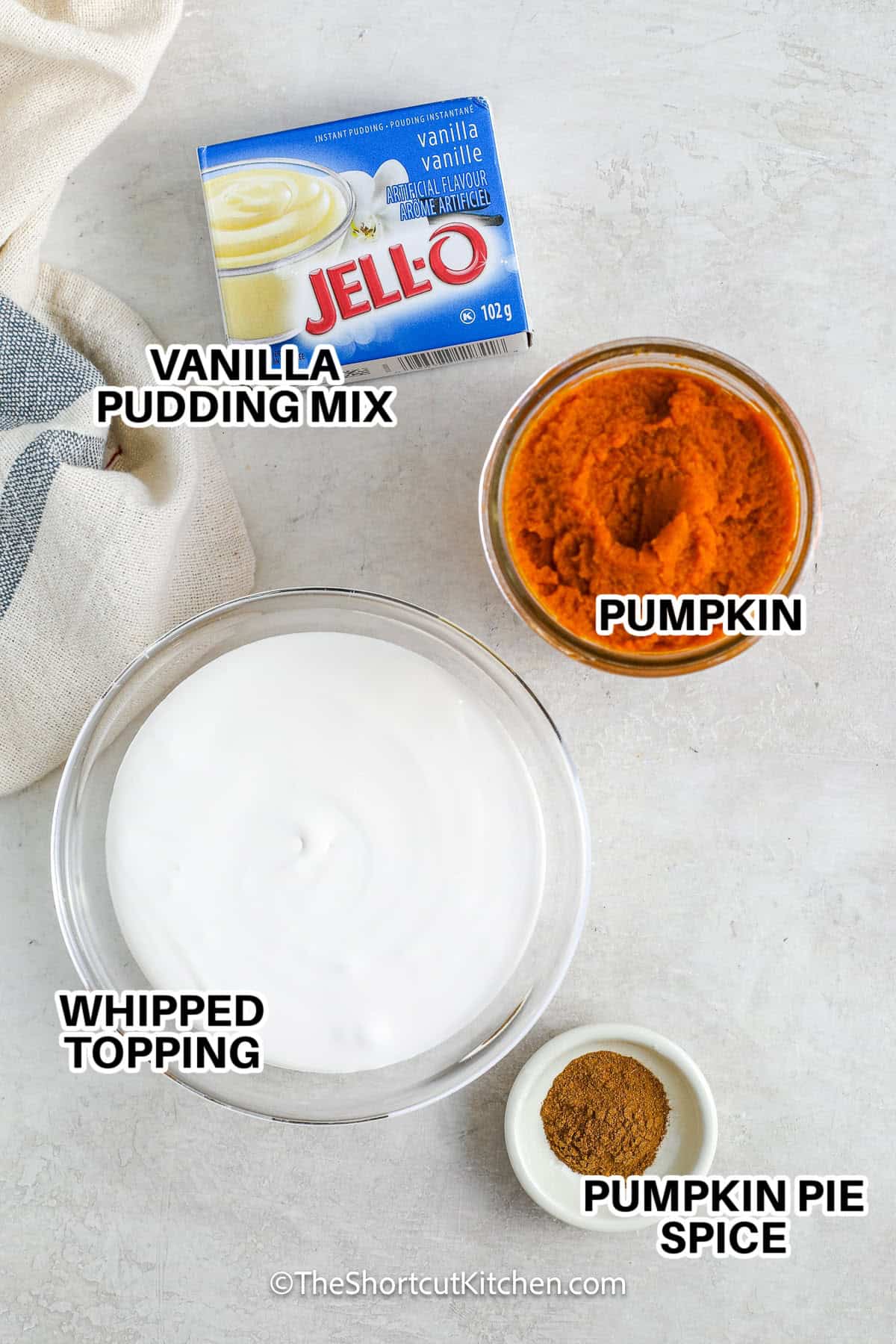 ingredients to make pumpkin dip labelled: vanilla pudding mix, pumpkin, whipped topping, and pumpkin pie spice