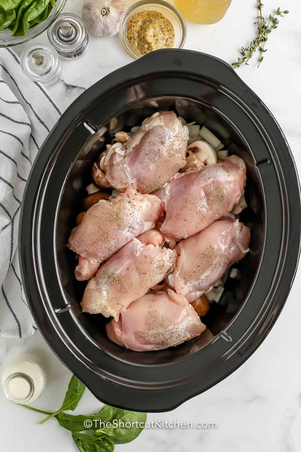 adding chicken and seasonings to pot to make Slow Cooker Chicken Thighs Recipe