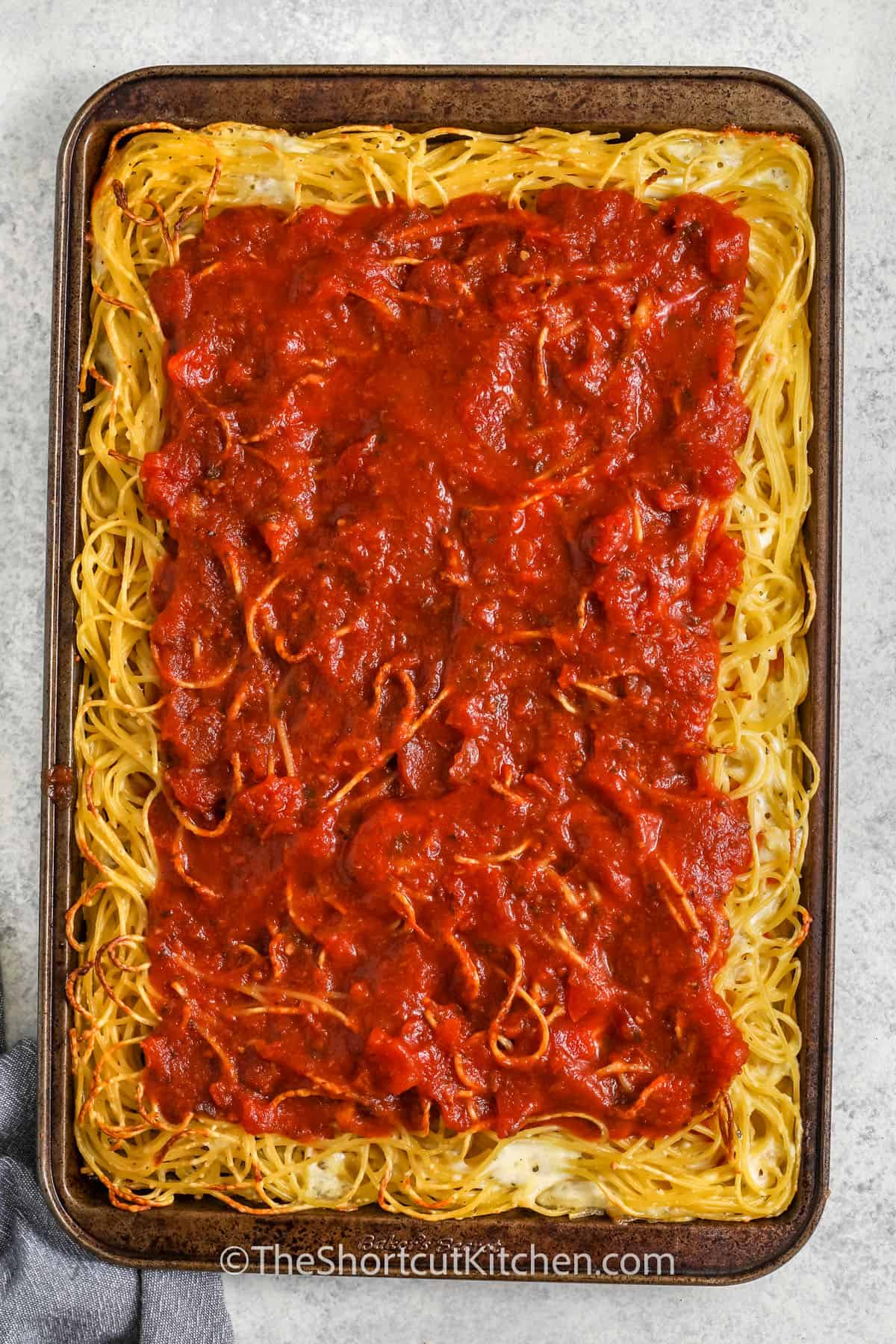 adding pizza sauce to Spaghetti Pizza