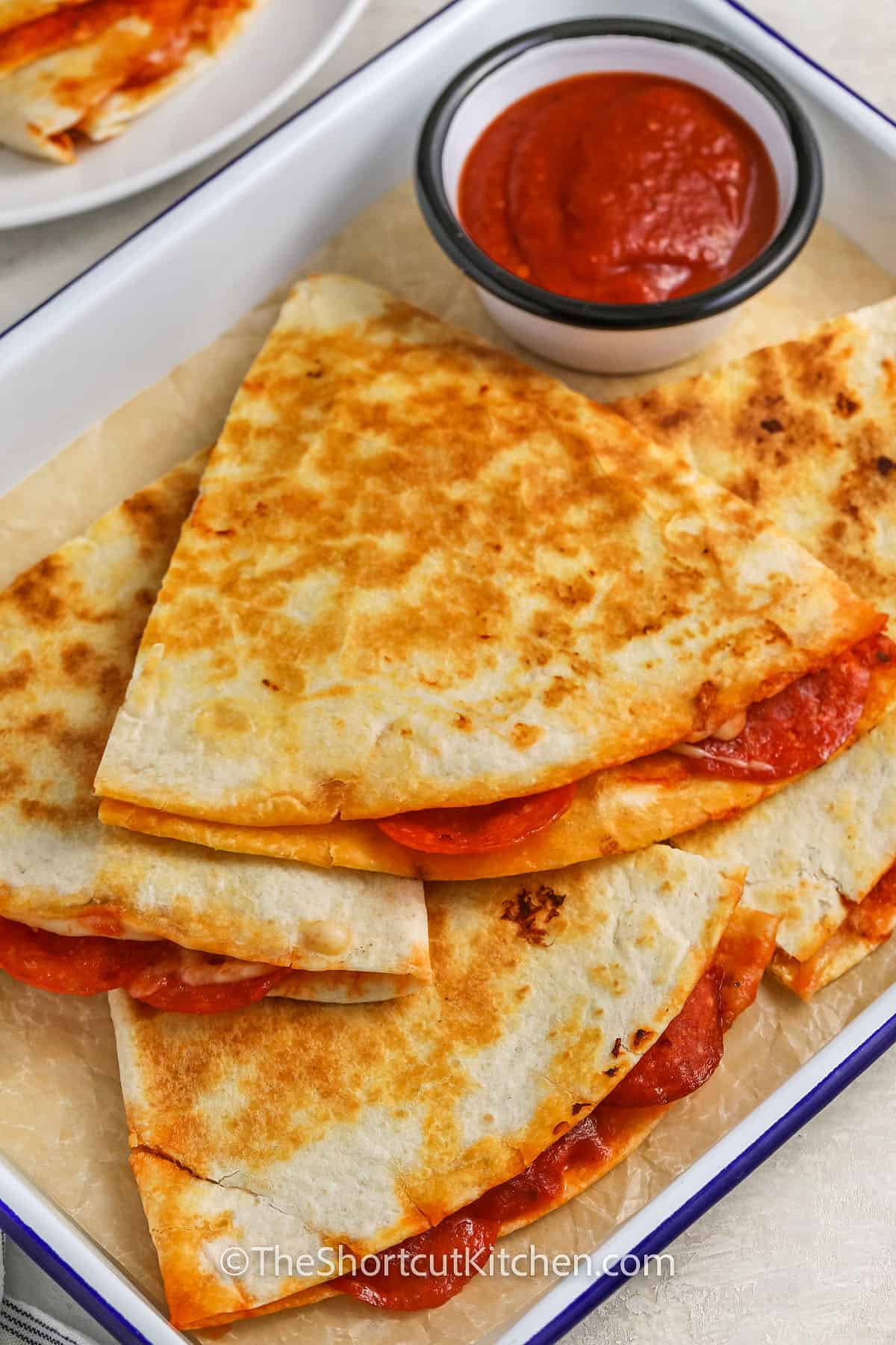 close up of Pizza Quesadilla with marinara on a plate