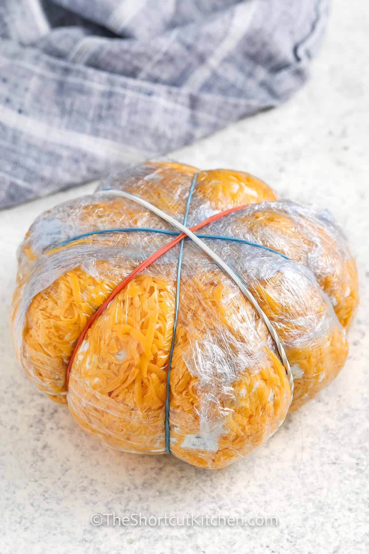 pumpkin cheese ball wrapped in plastic wrap