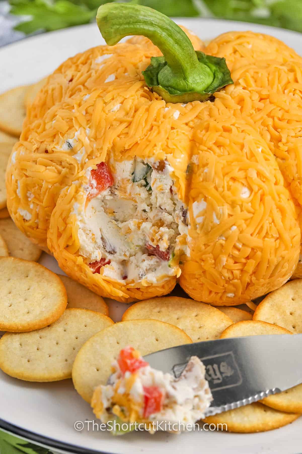 Pumpkin Cheese Ball with a piece on a knice