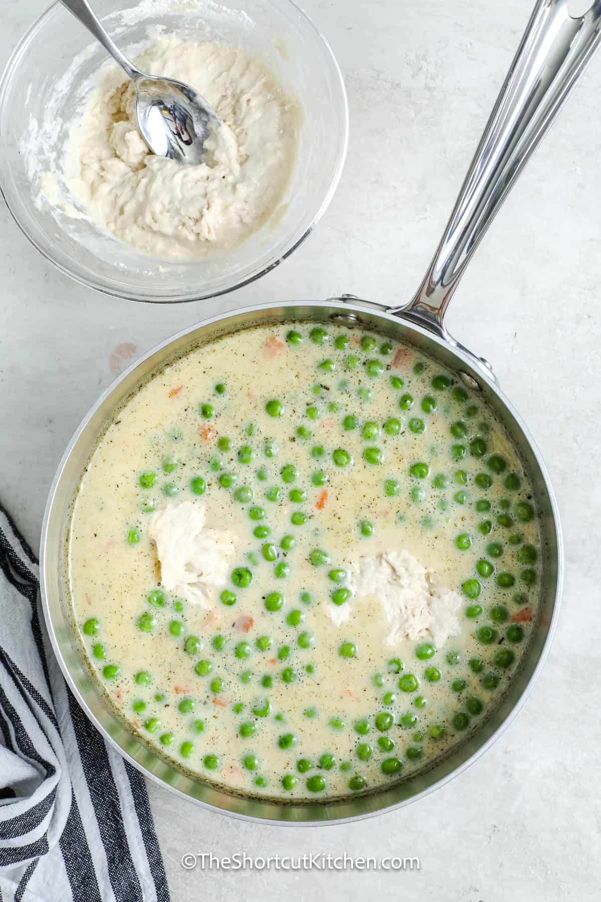 dumplings being added to the chicken mixture in a sauce pan