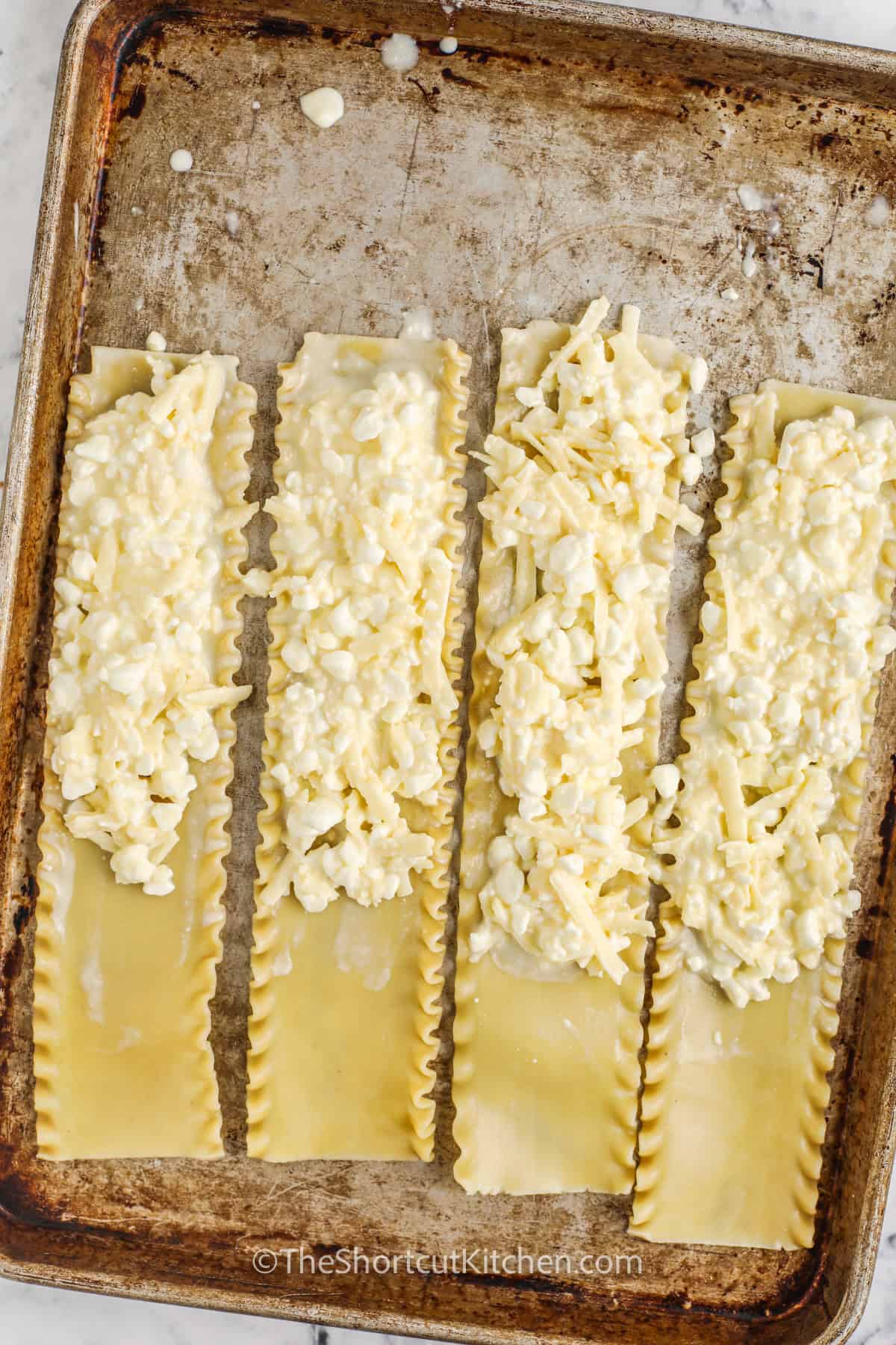 adding cheese filling to lasagna sheets to make Three Cheese Lasagna Rolls