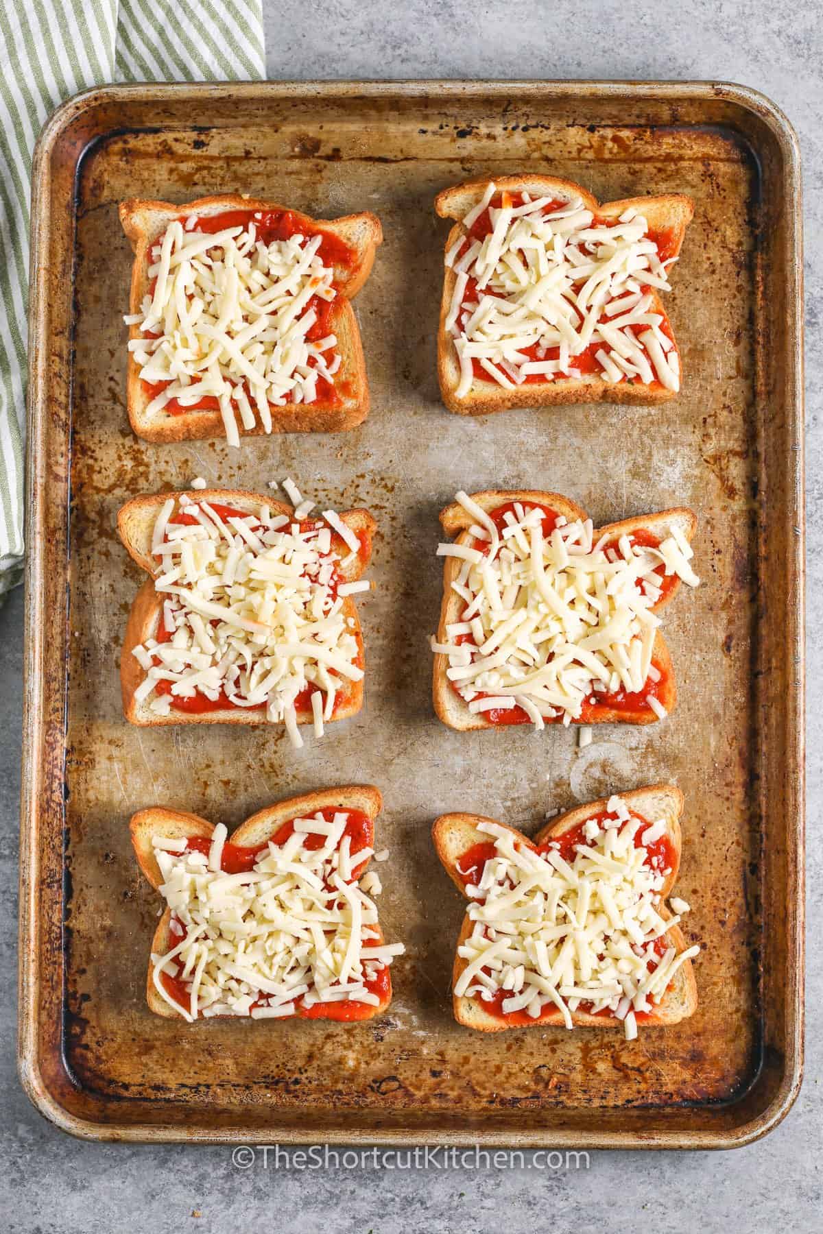 adding cheese to texas toast to make Texas Toast Pizza