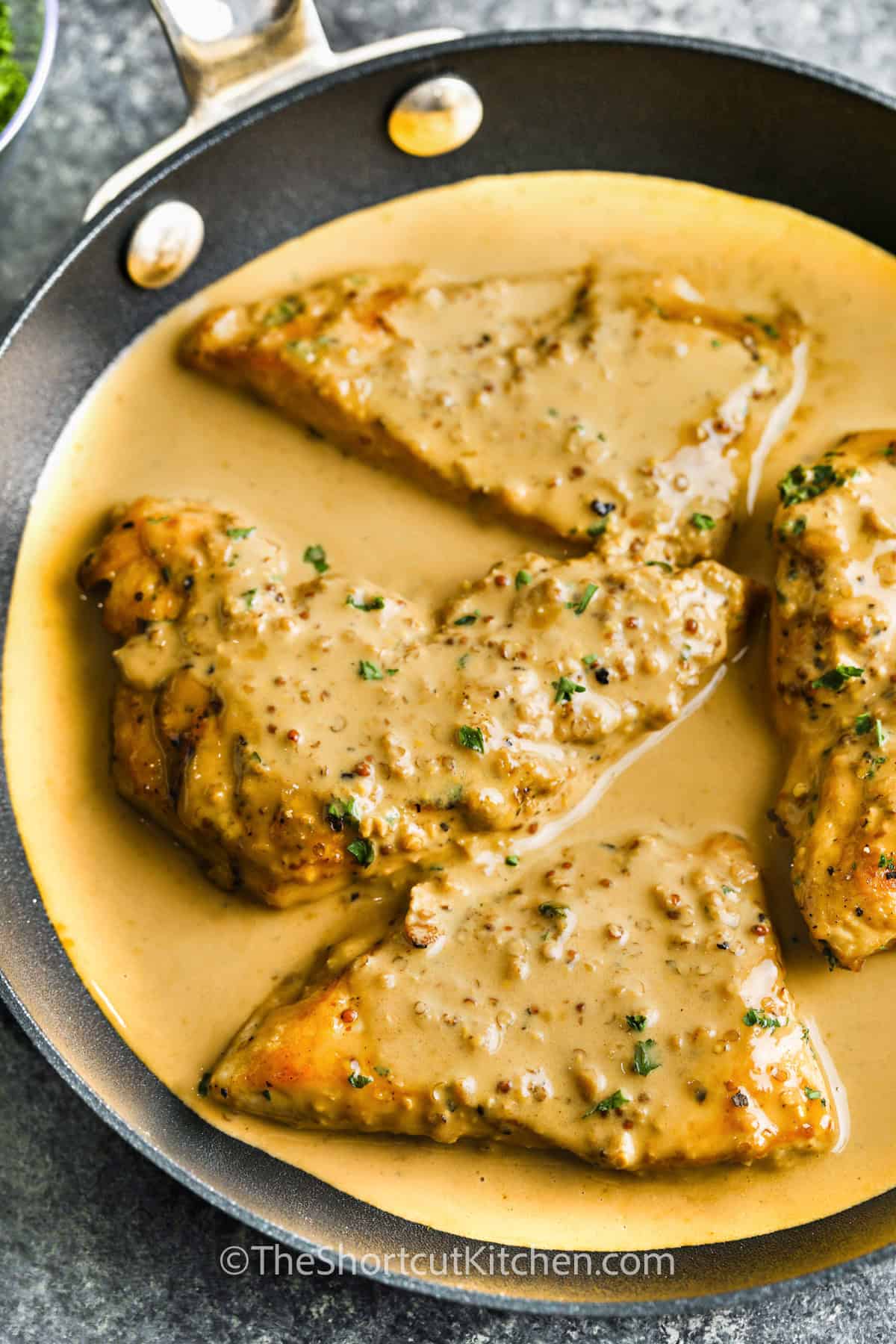 Dijon chicken is a simple yet elegant dish that’s bursting with flavor. Tender chicken breasts are cooked in a creamy, mustard-infused sauce with hints of soy sauce and white wine. This easy skillet recipe is perfect for a comforting dinner that feels fancy but takes minimal effort. Serve over rice or noodles to soak up every drop of the delicious sauce. #theshortcutkitchen pan of Creamy Dijon Chicken