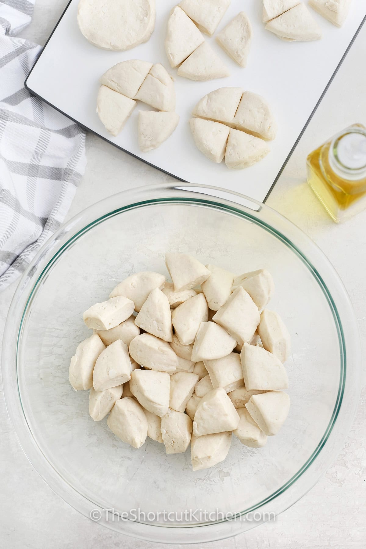 adding bread pieces to bowl to make Pull Apart Pizza Bread