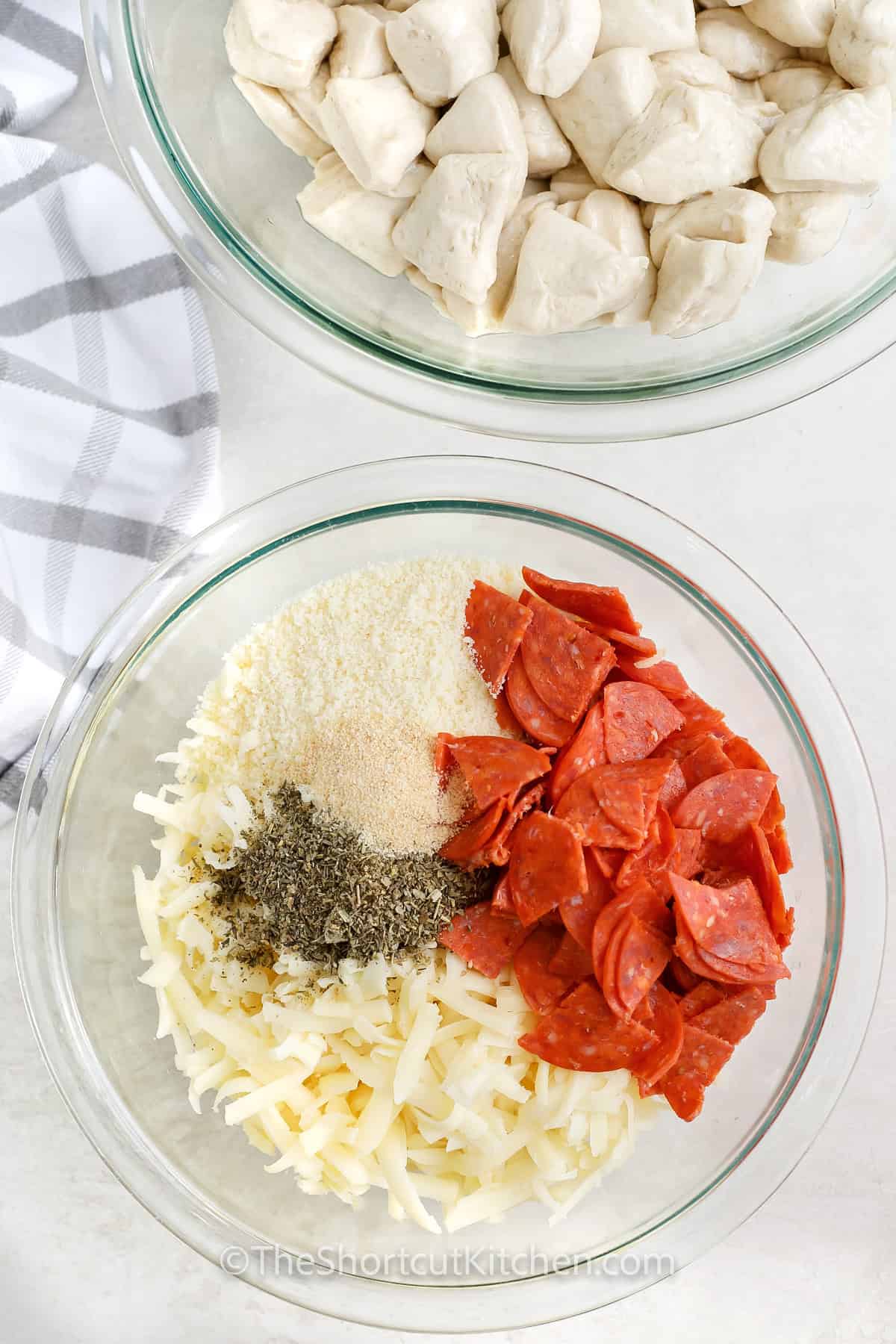 adding ingredients to bowl to make pepperoni filling for Pull Apart Pizza Bread