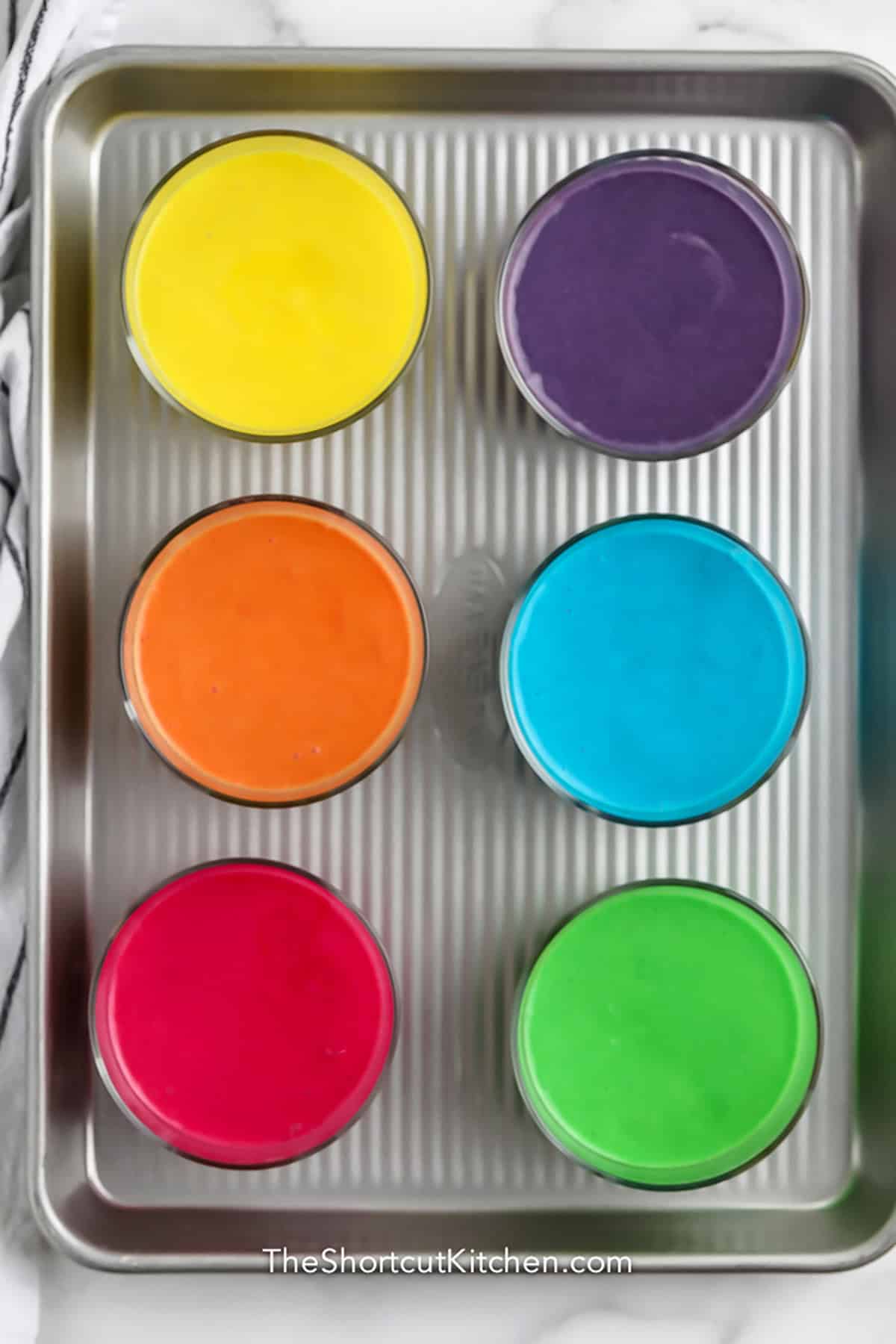 cupcake batter in glasses that are different colors to make Rainbow Cupcakes