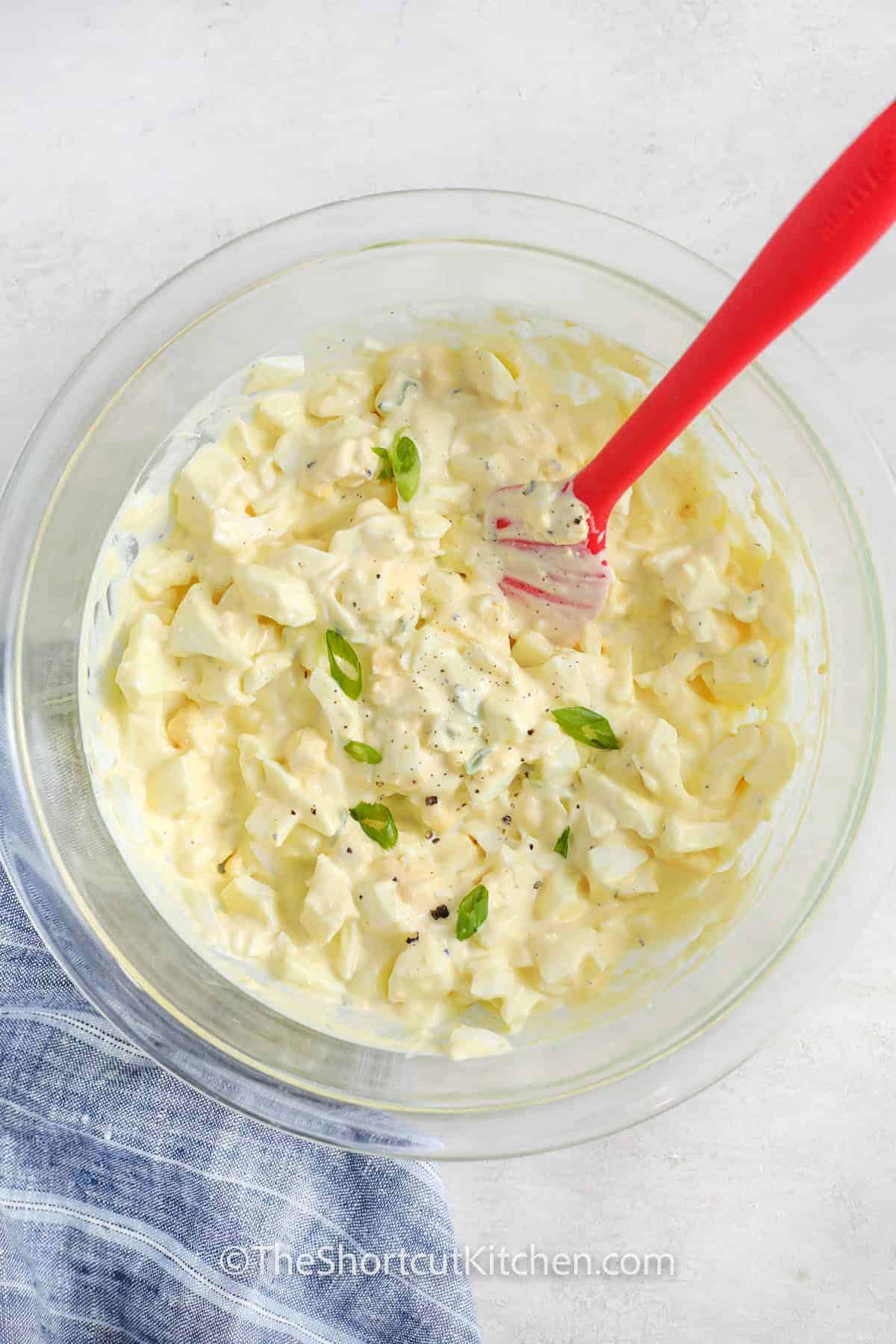 Best Egg Salad Recipe in a bowl with green onion , salt and pepper