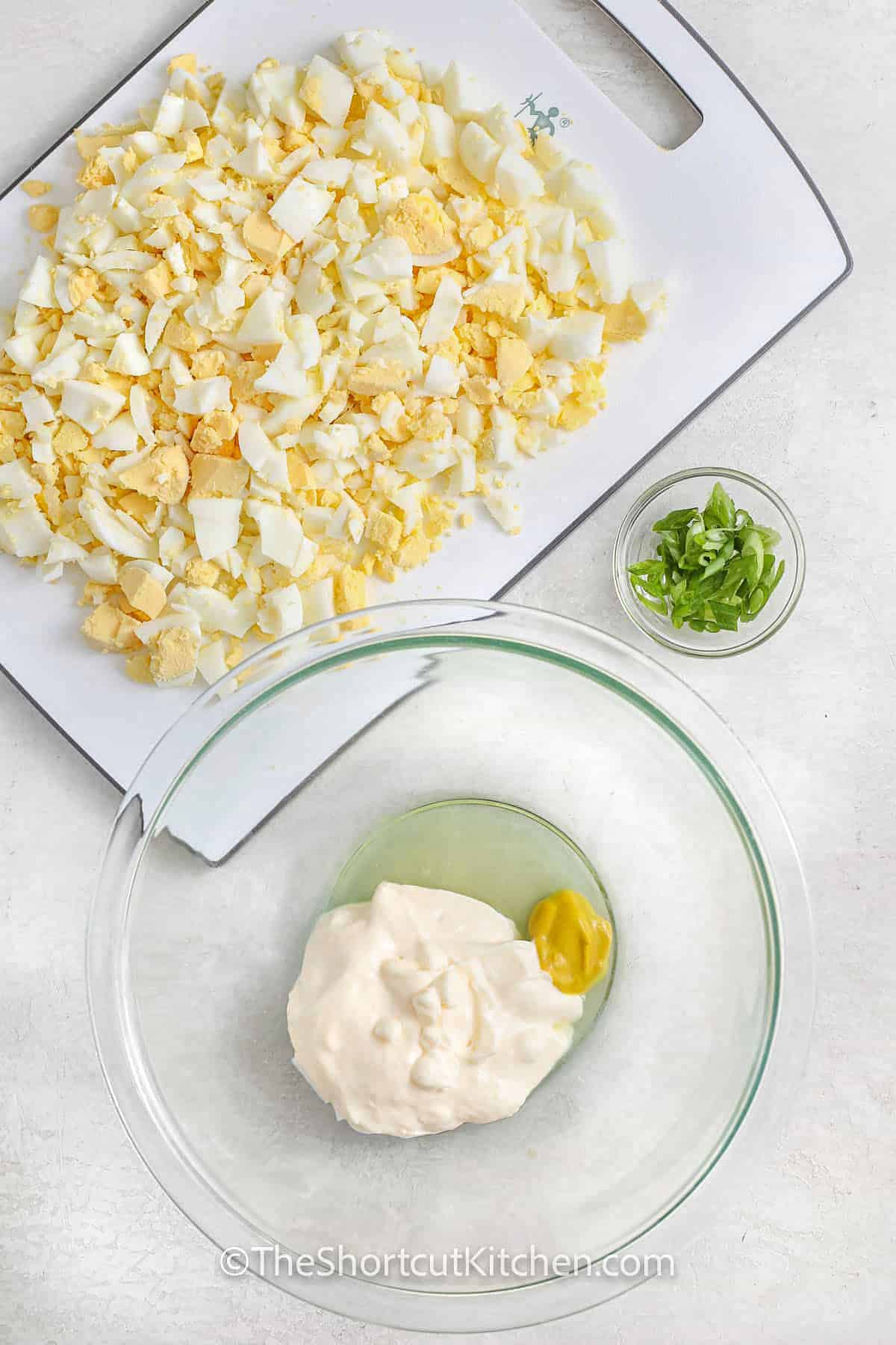 adding ingredients to bowl to make Best Egg Salad Recipe