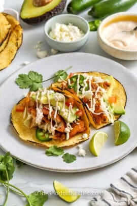 plated Cod Fish Tacos with dressing drizzled over the top