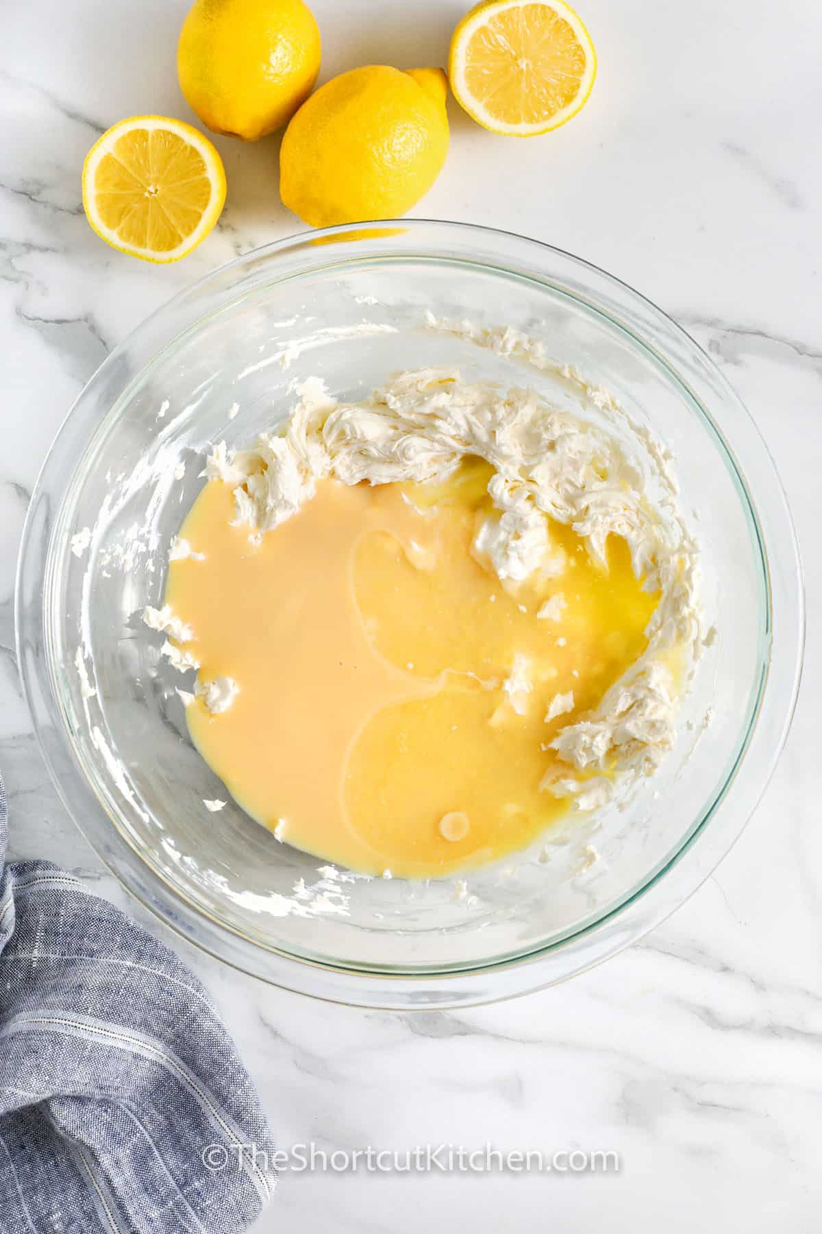 adding condensed milk with lemon to whipped cream cheese to make Creamy Lemon Pie Recipe