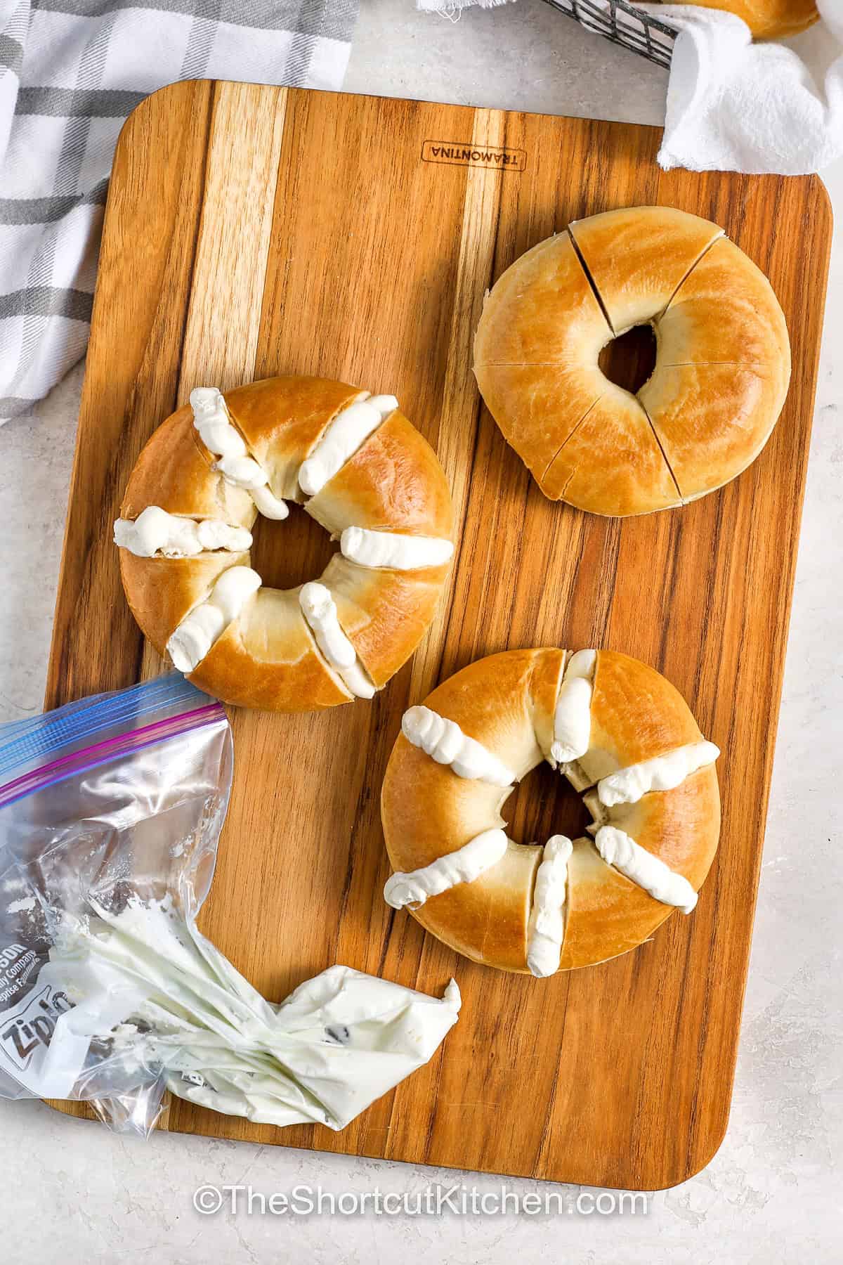 adding cream cheese to slits in bagels to make Stuffed Bagels