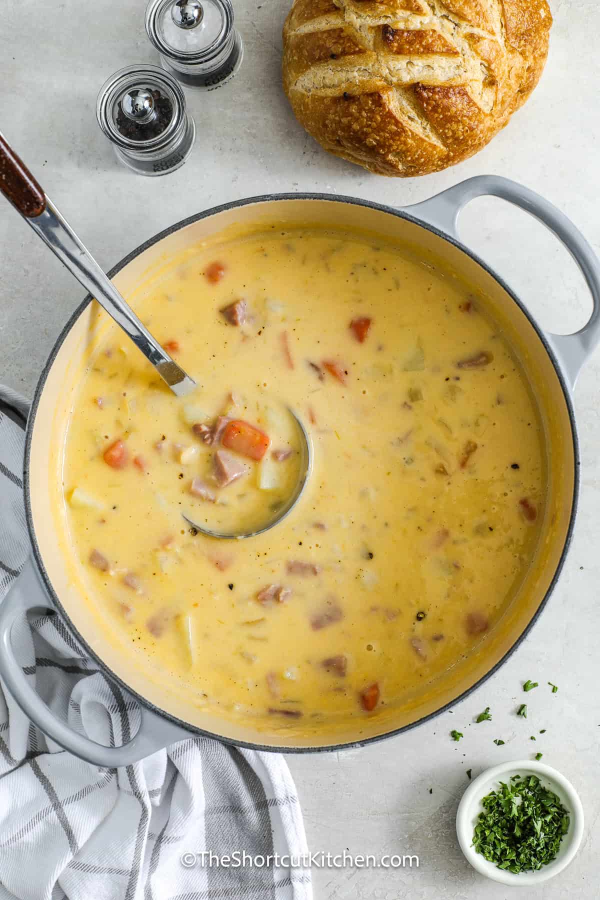 Cheesy ham and potato soup is a rich and creamy dish, perfect for those who love cheesy comfort food. This recipe combines tender potatoes, savory ham, and melted Velveeta cheddar cheese for a soup that's full of flavor. The cream adds a smooth richness to each bite, and it's all cooked up in one pot for easy preparation and cleanup. It’s a cheesy and satisfying meal everyone will enjoy. #theshortcutkitchen cheesy ham and potato soup in a pot