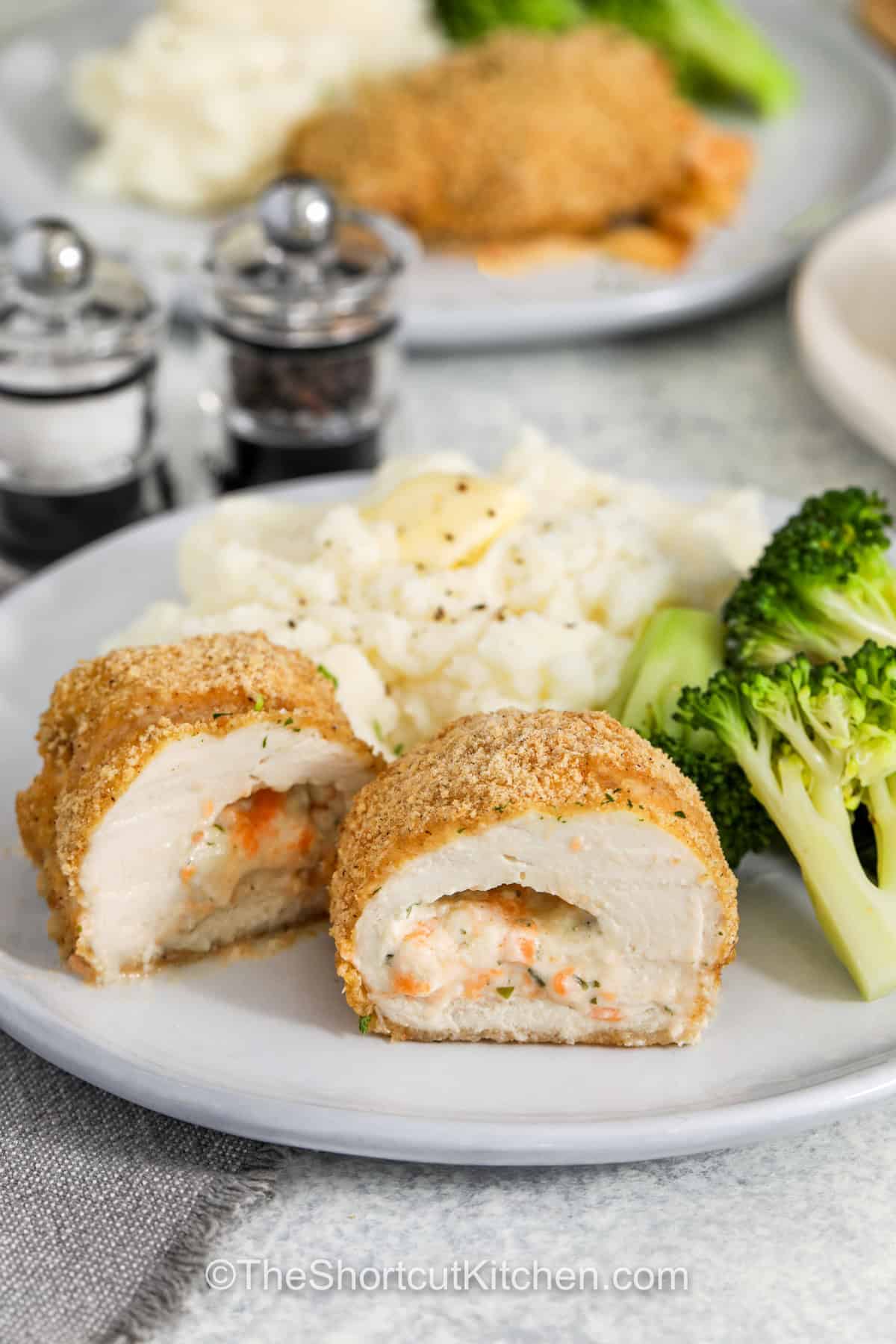 Chicken rolls are a cheesy, breaded delight that everyone will love! This easy recipe features tender chicken stuffed with cream cheese and shredded cheese, dipped in egg, and baked until golden and crispy. With a crunchy outside and a melty inside, every bite is full of flavor. Serve with your favorite dipping sauce or a simple side for a satisfying meal. Whether for a family dinner or a special treat, these chicken rolls always impress! #theshortcutkitchen cheesy stuffed Chicken Rolls on a plate