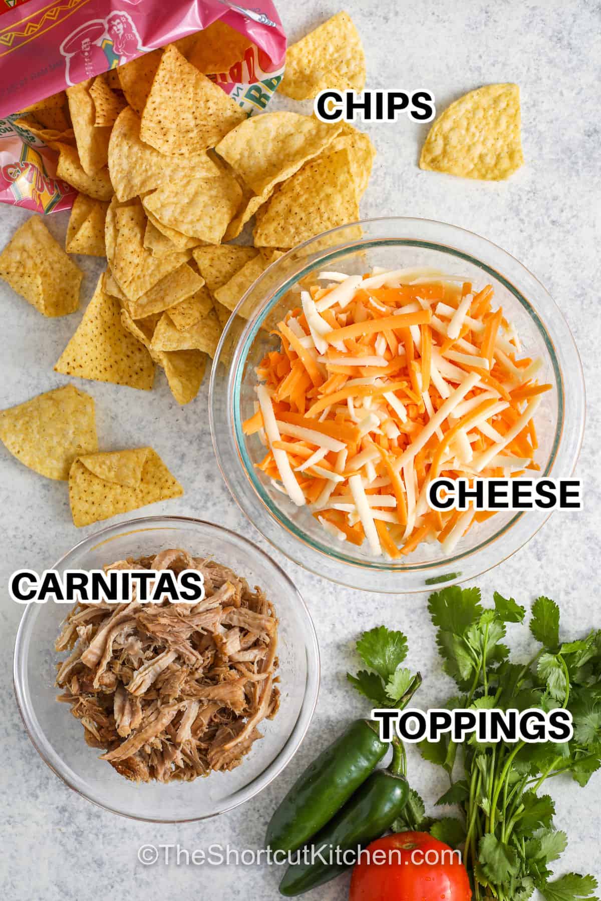 chips , cheese , carnitas , and toppings to make Carnitas Nachos with labels