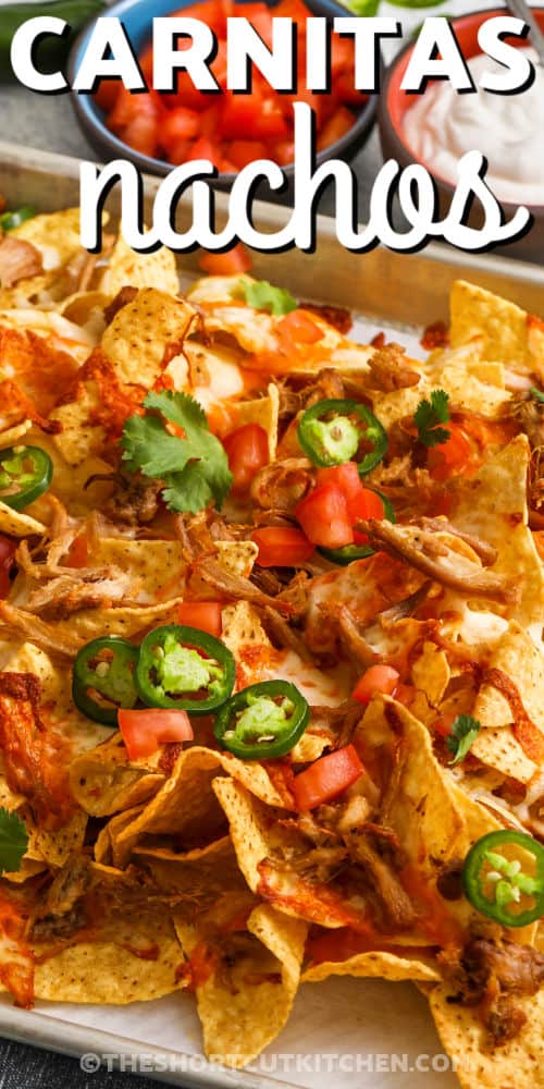 close up of Carnitas Nachos with tomatoes and jalapeños slices and a title