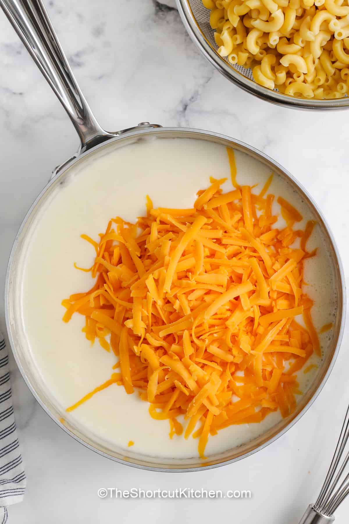 cheese being added to a cream sauce