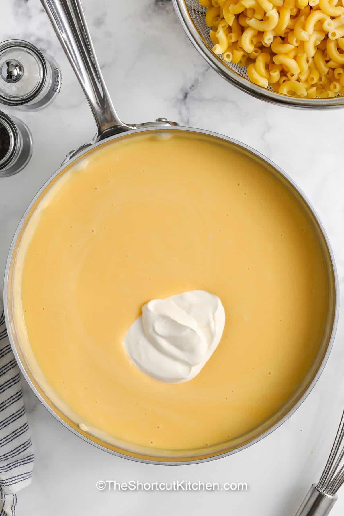 sour cream being added to a cheese sauce
