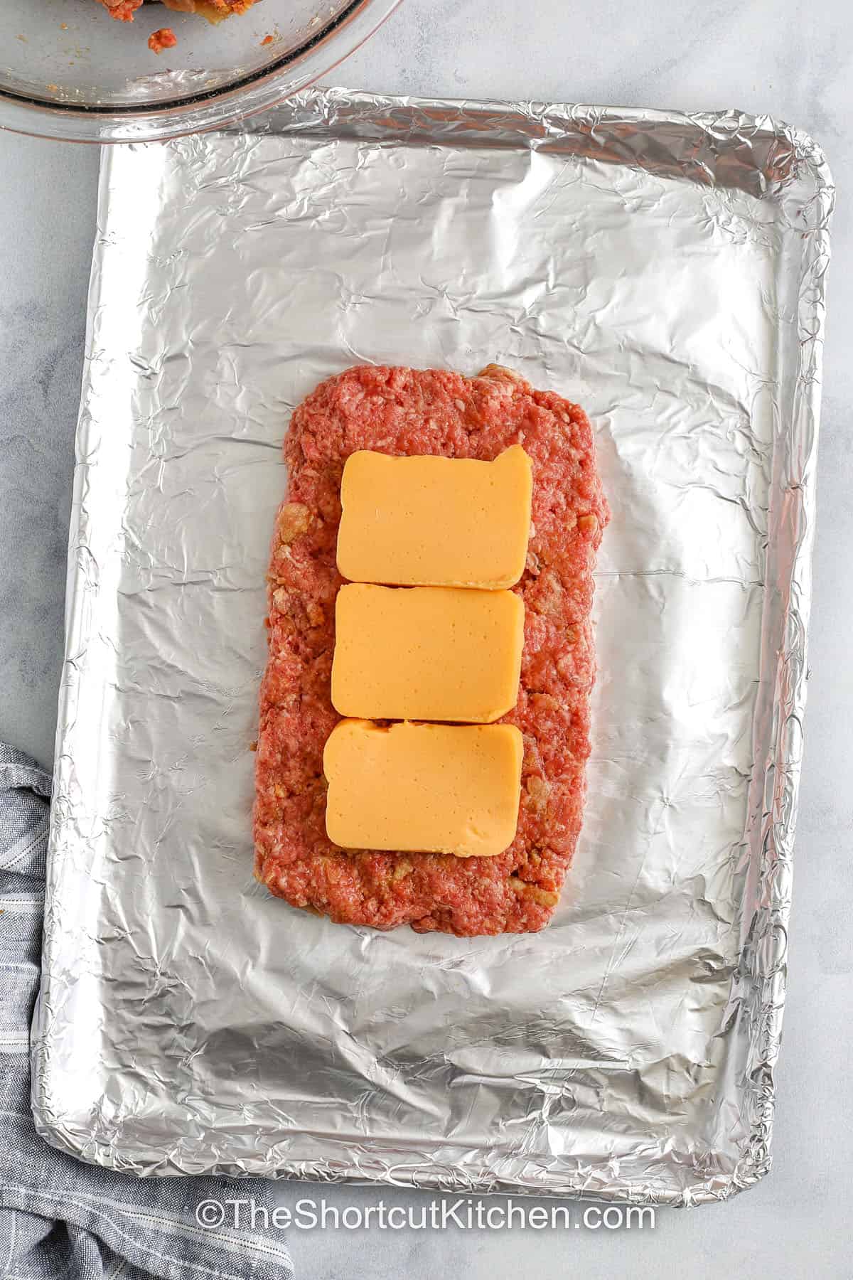top view of uncooked meatloaf with cheese layer