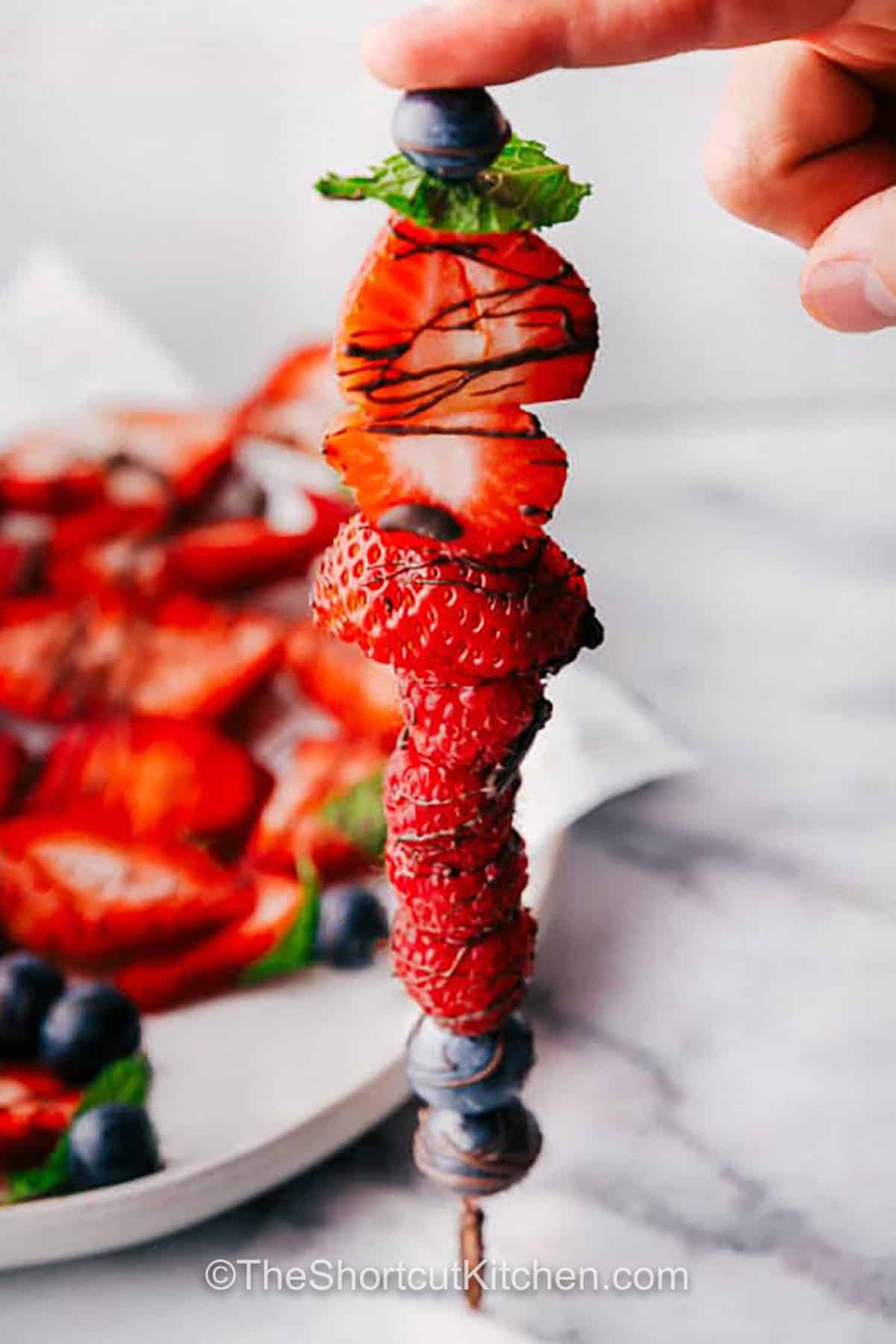 Fruit Kabob Recipe with plate full in the back