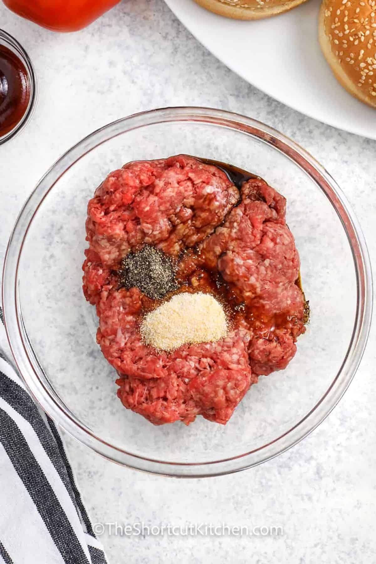 adding seasonings to beef to make Great Grilled Burgers