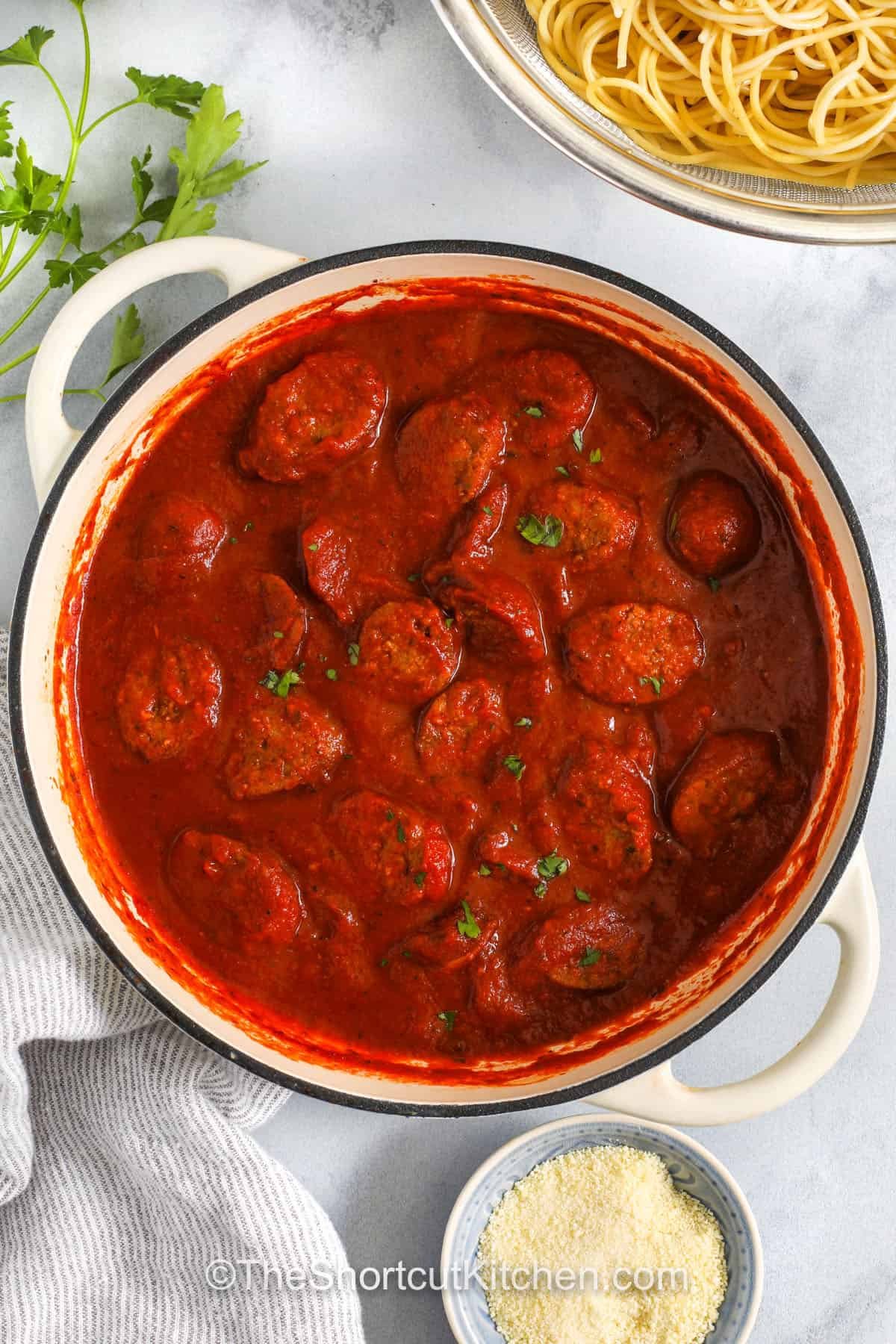 cooked italian sausage in sauce with a strainer full of spaghetti to make Italian Sausage Spaghetti