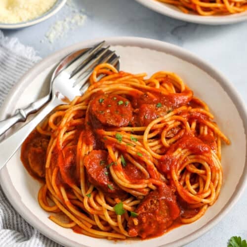 Italian Sausage Spaghetti in a bowl with a fork and spoon