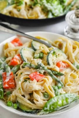 plated Pasta Primavera with pan full in the back