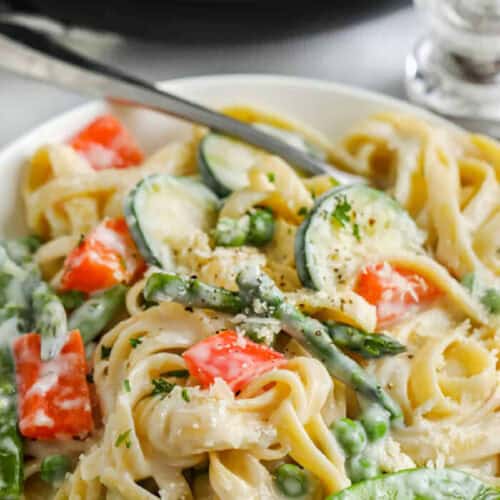 plated Pasta Primavera with pan full in the back