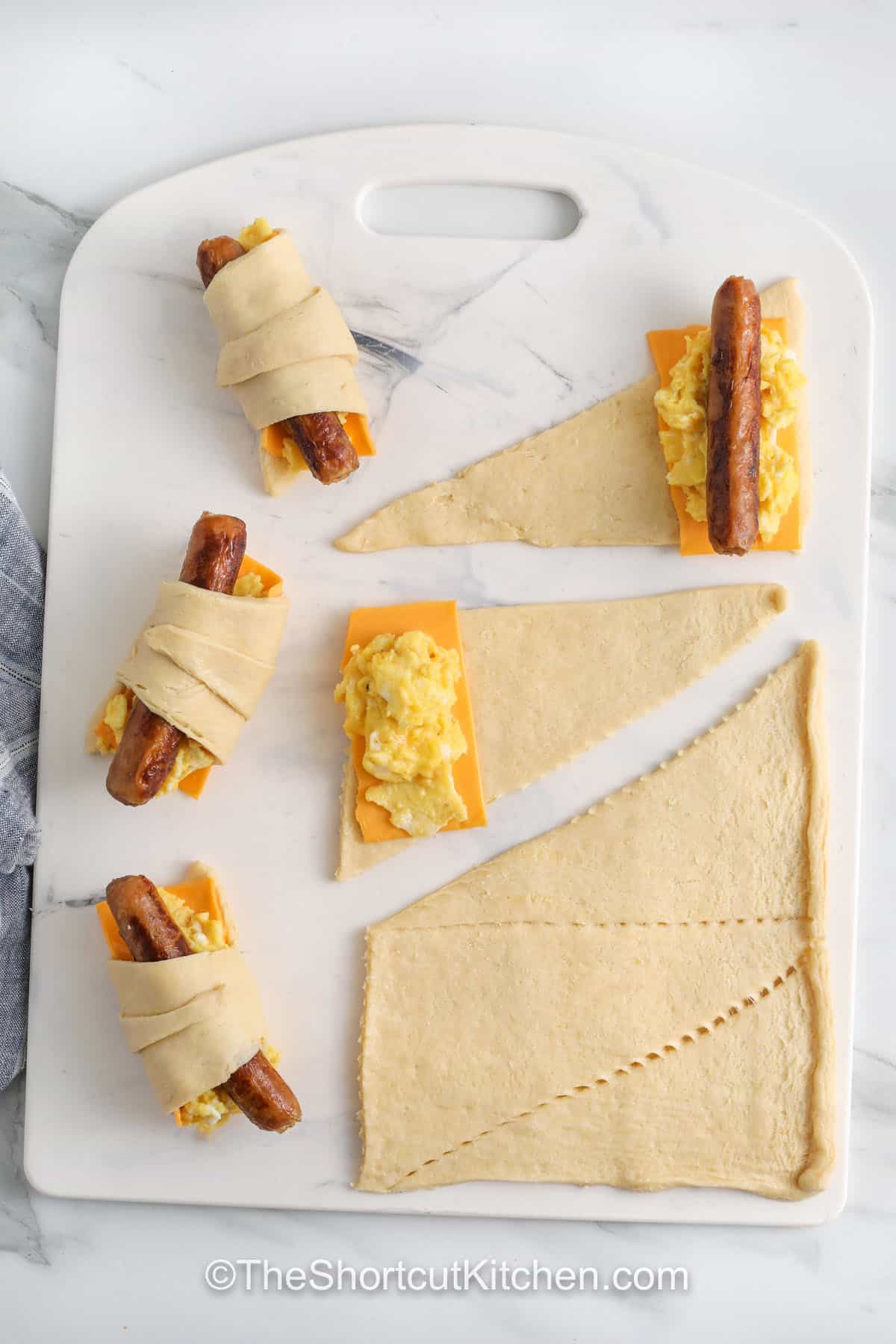 rolling ingredients in crescent roll dough to make Crescent Roll Breakfast