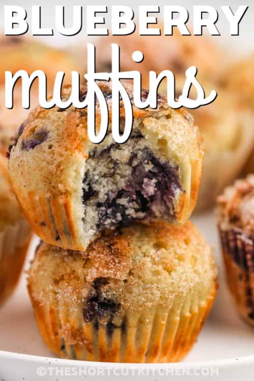close up of a stack of Easy Blueberry Muffins Recipe with a bite taken out of one and a title
