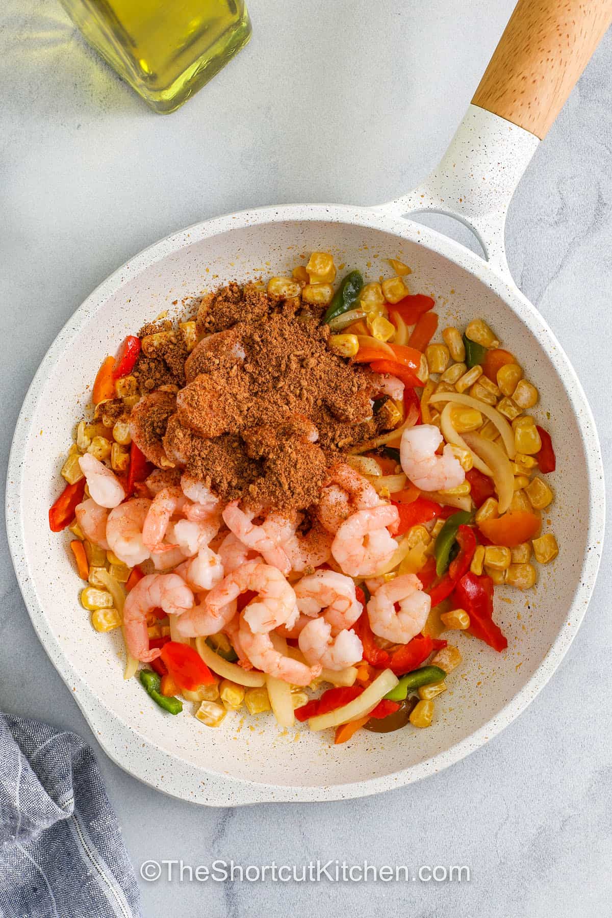 adding seasonings to shrimp and vegetables to make Shrimp Quesadillas