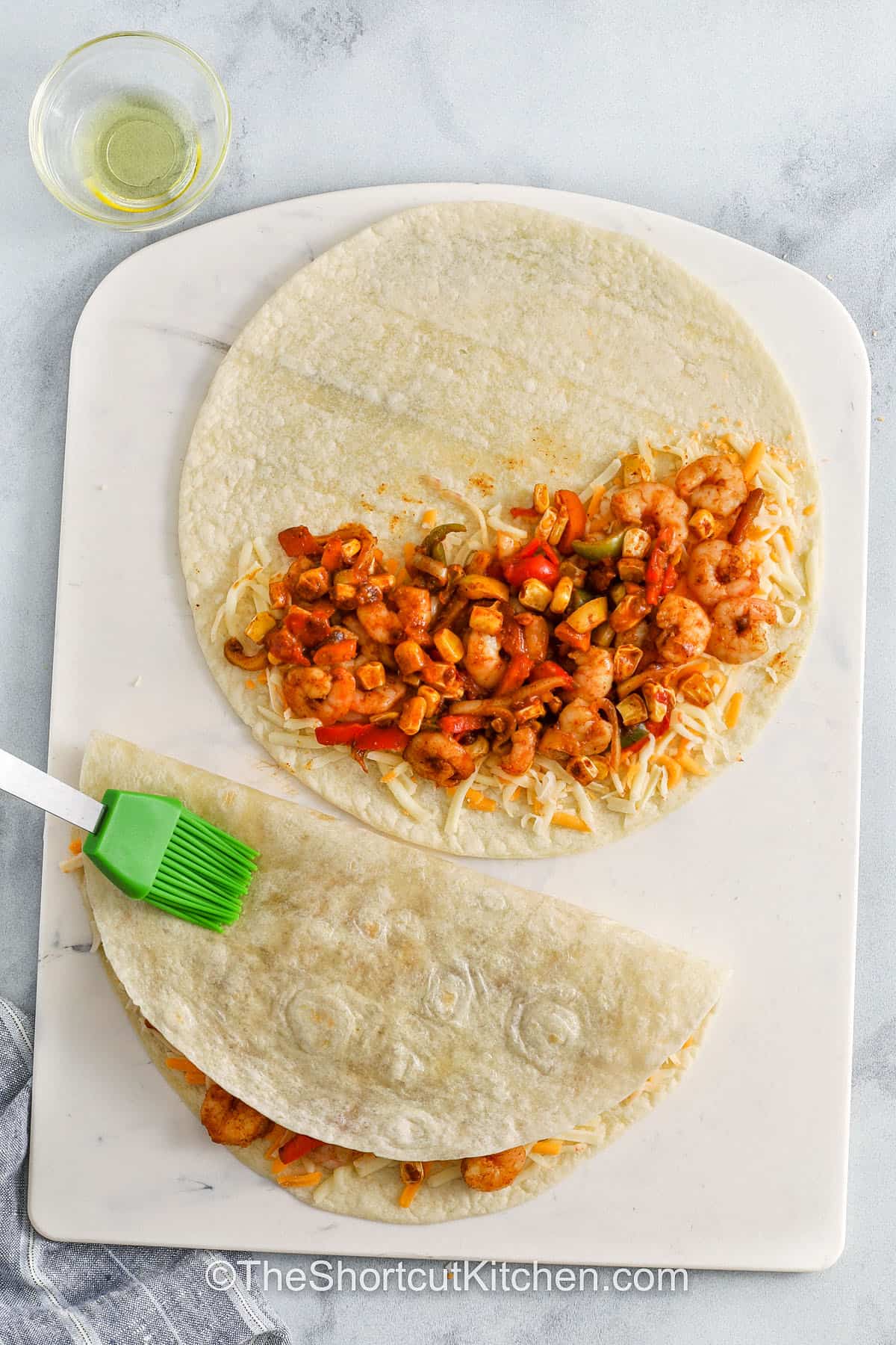 brushing oil over Shrimp Quesadillas before frying