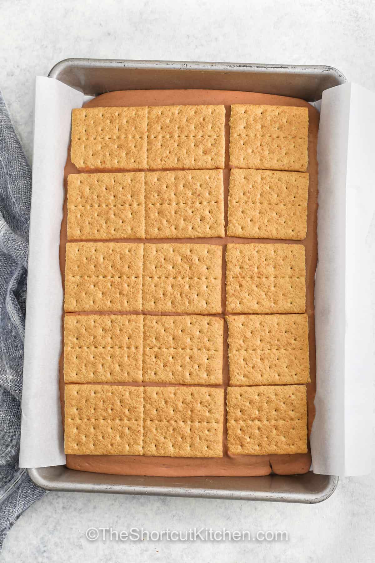 s'mores in a pan topped with graham crackers